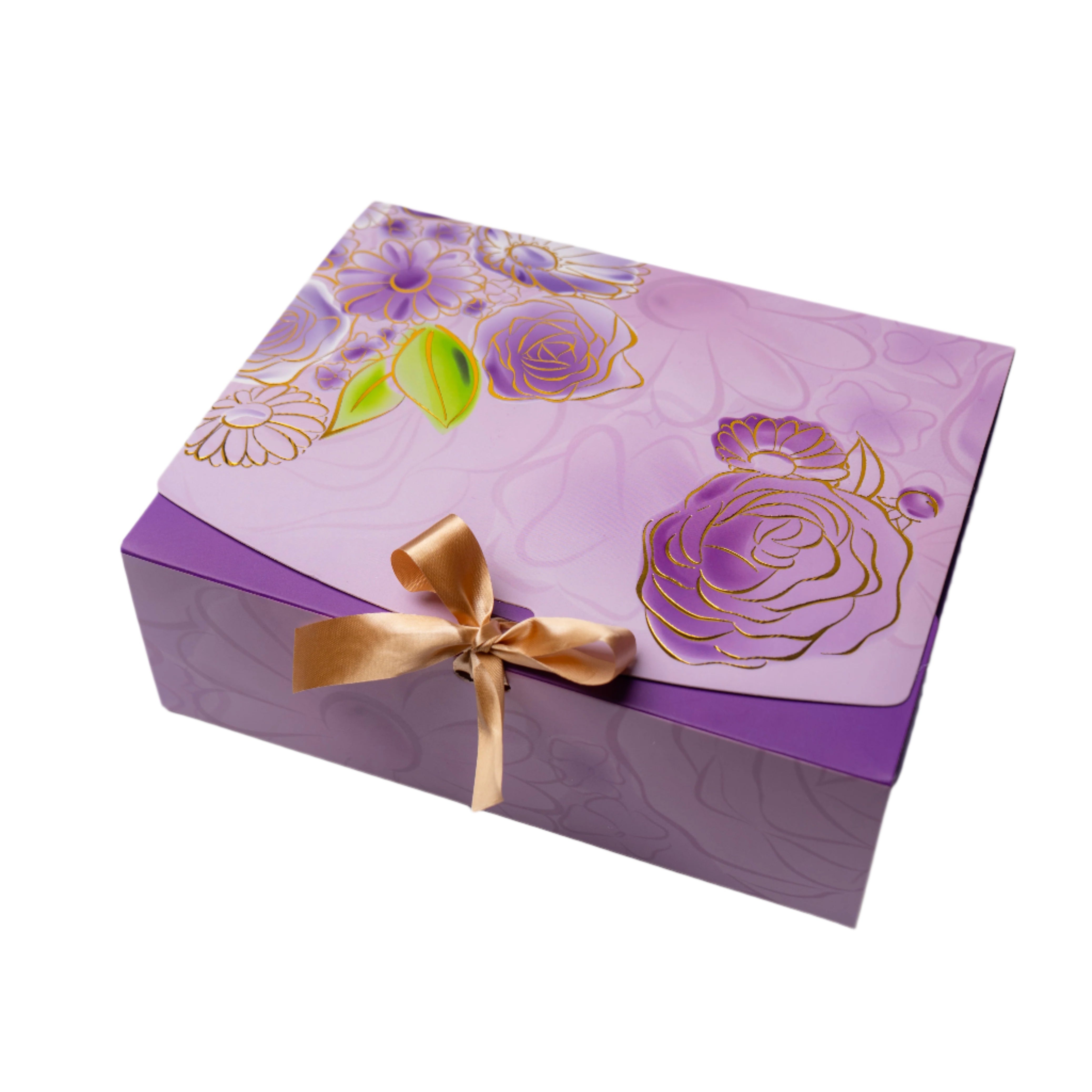Decorative purple gift box with floral design and gold ribbon on a light white background