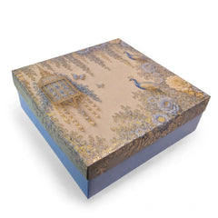 A square decorative gift box with a lid featuring an ornate toile-style print of peacocks, floral motifs, and hanging pearl-like beads, with a solid blue base and sides, shown on a white background.